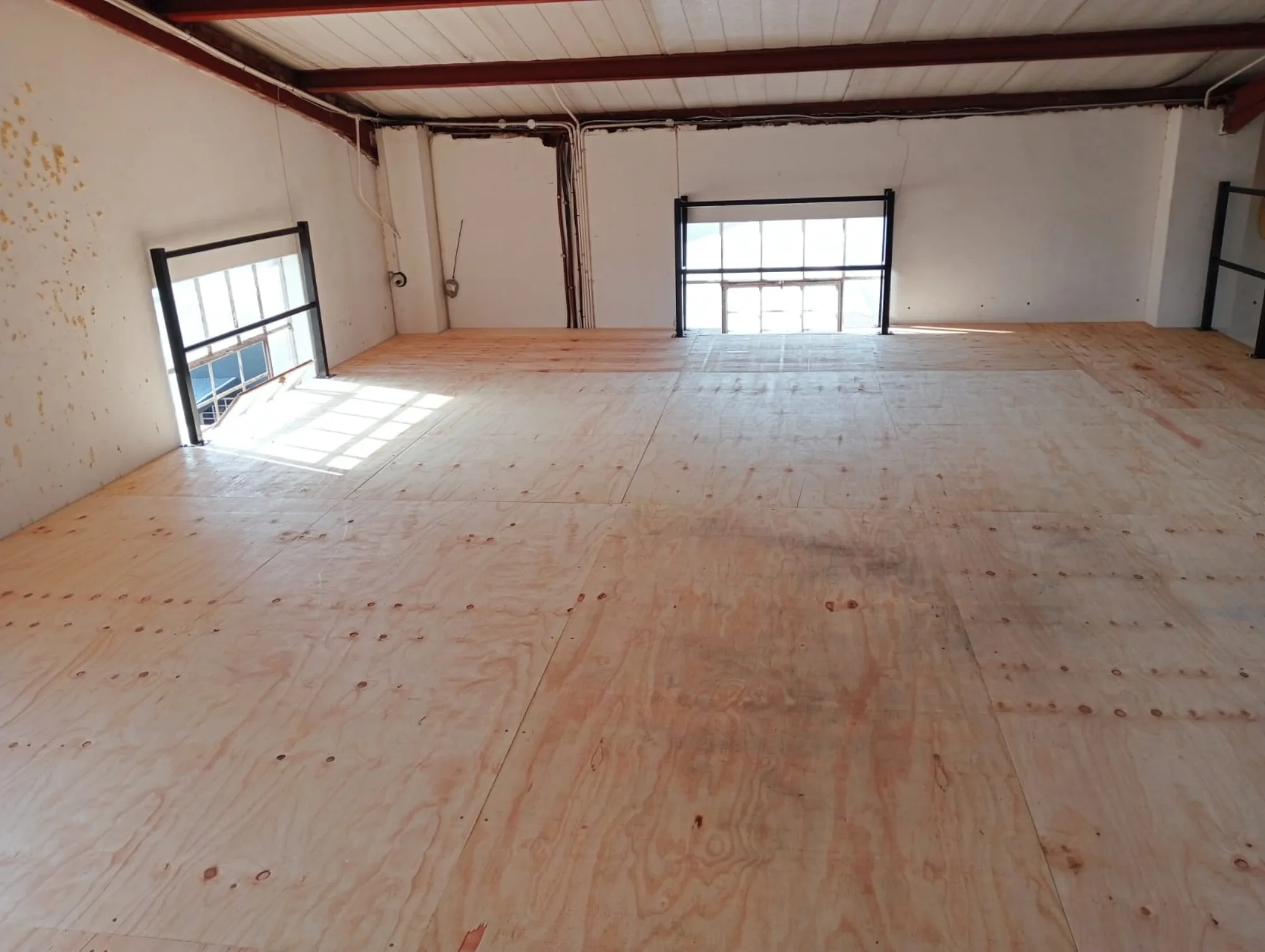 Timber decked mezzanine floor with balustrade and windows behind